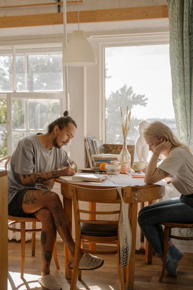 A man and a woman sitting together at a dining room table.