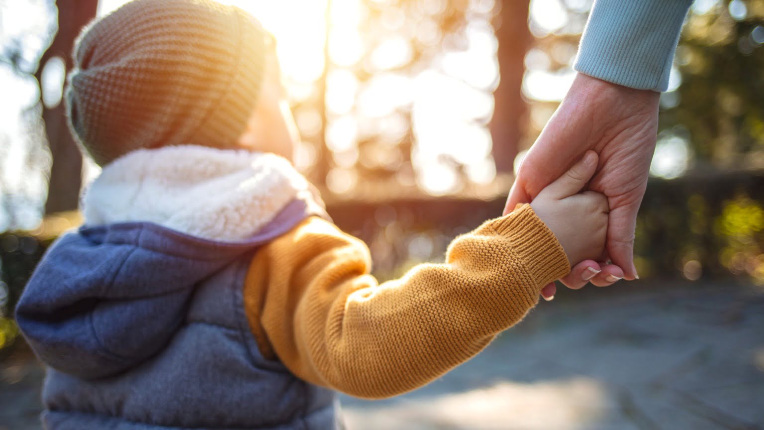 A child holding their parent's hand.