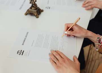 Two people signing a divorce decree document.