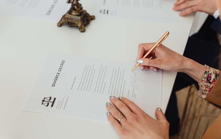 Two people signing a divorce decree document.