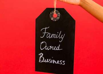 A person holds a sign that says "family owned business."