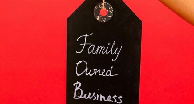 A person holds a sign that says "family owned business."