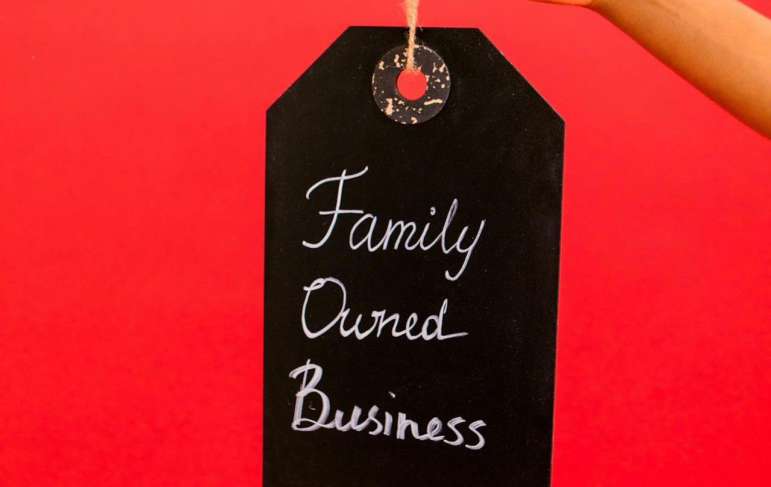 A person holds a sign that says "family owned business."
