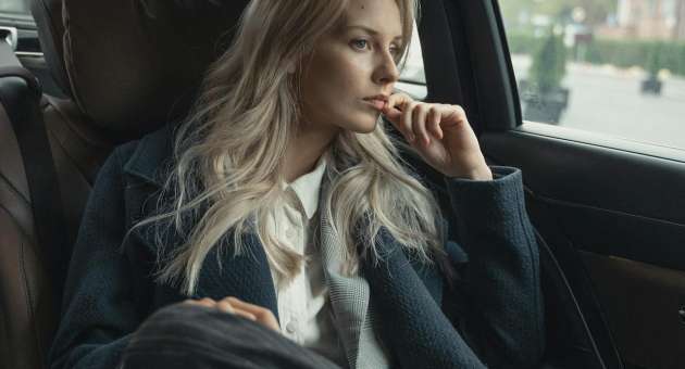 A woman sitting in the backseat of a car.